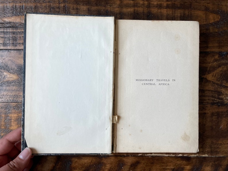 May include: An open book with a white cover and black text that reads "Missionary Travels in Central Africa".