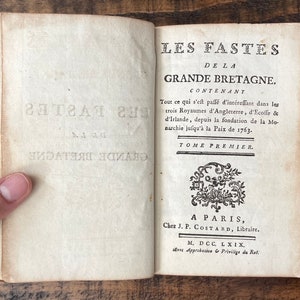 May include: A vintage book titled "Les Fastes de la Grande Bretagne" with the text "Tome Premier" and "A Paris, Chez J.P. Costard, Libraire. M. DCC. LXIX, avec Approbation & Privilige du Rot."