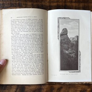 May include: A black and white photograph of a rocky mountain range. The image is from a book titled "Missionary Travels by E.G. Arnot". The caption below the image reads "The Black Rocks of Puma Ngoho."
