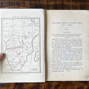 May include: An open book with a map of Africa and text about missionary travels in Central Africa by P.S. Arnot. The map shows the route from Natal to Kama's Country.