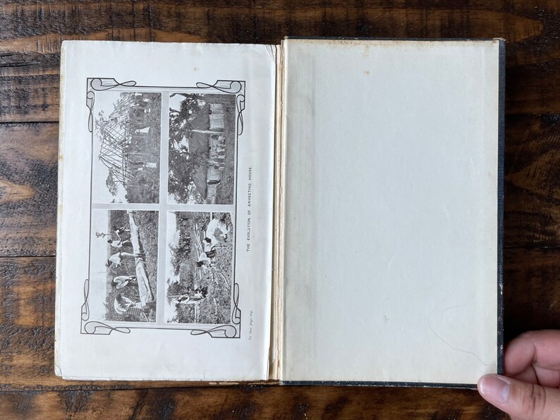 May include: An open book with black binding and a white interior. The book has four black and white photographs of a construction project. The text on the page reads "The Evolution of the American School".