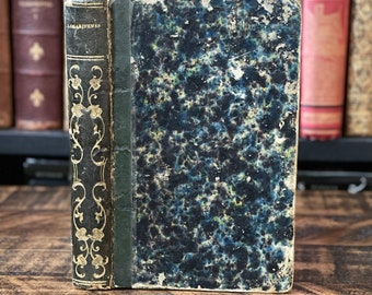 Könnte beinhalten: Ein Vintage-Buch in dunkelblau mit marmoriertem Muster, goldenen Akzenten und dem Wort "LOGARITHMES" auf dem Rücken.