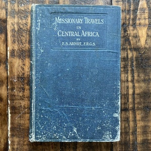 May include: A blue book with the title "Missionary Travels in Central Africa" by F.S. Arnot, F.R.G.S.