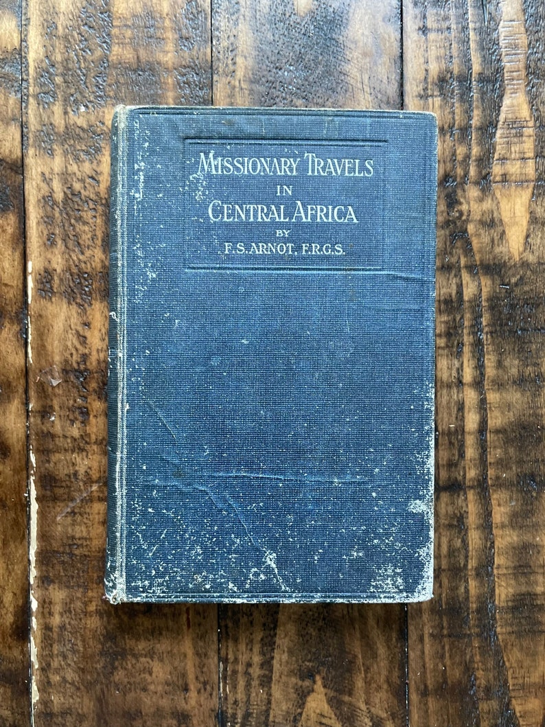 May include: A blue book with the title "Missionary Travels in Central Africa" by F.S. Arnot, F.R.G.S.