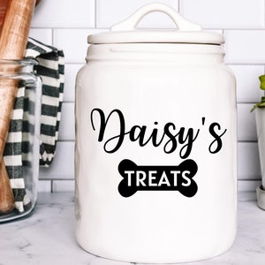 May include: White ceramic jar with a black bone-shaped design and the text "Daisy's Treats".