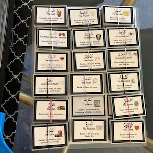 May include: A set of 16 colorful cards with Arabic text and English translations. Each card features a different name of God in Arabic, along with the English translation and a description of the benefits of reciting that name. The cards are designed to be used for spiritual reflection and meditation.