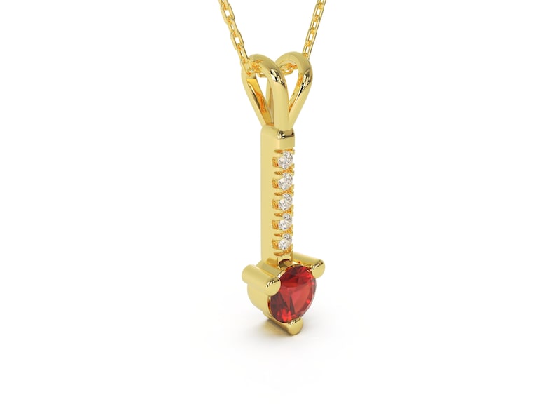 Puede incluir: Un collar de oro con un colgante que tiene una piedra roja y una fila de piedras transparentes.