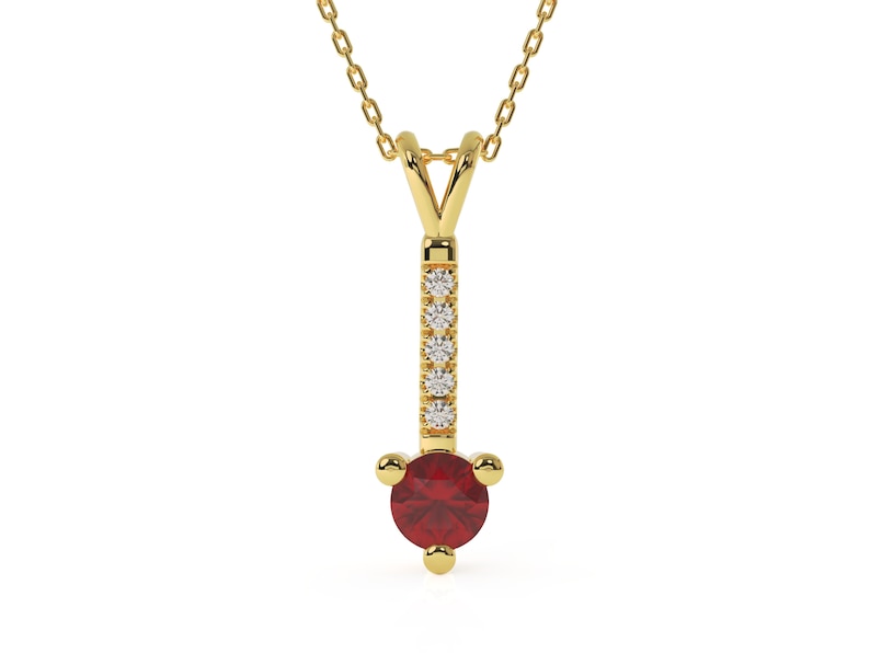 Puede incluir: Un collar de oro con un colgante de piedra roja y peque&ntilde;as piedras transparentes. El colgante est&aacute; en una cadena de oro delicada.
