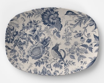 May include: A white oval serving platter with a blue floral pattern and birds. The pattern features blue flowers, leaves, and birds on a white background.