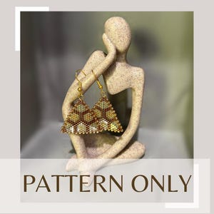 Könnte beinhalten: Ein Paar goldene Dreiecksohrringe mit einem geometrischen Muster aus braunen und goldenen Perlen. Die Ohrringe werden auf einer kleinen, beigefarbenen Keramikskulptur präsentiert.