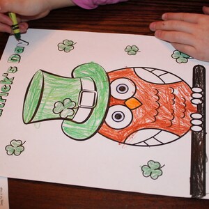 May include: A St. Patrick's Day coloring page featuring an owl wearing a green leprechaun hat and holding a black stick. The words "St. Patrick's Day" are written in green. The owl is colored orange and brown, with green shamrocks scattered around.