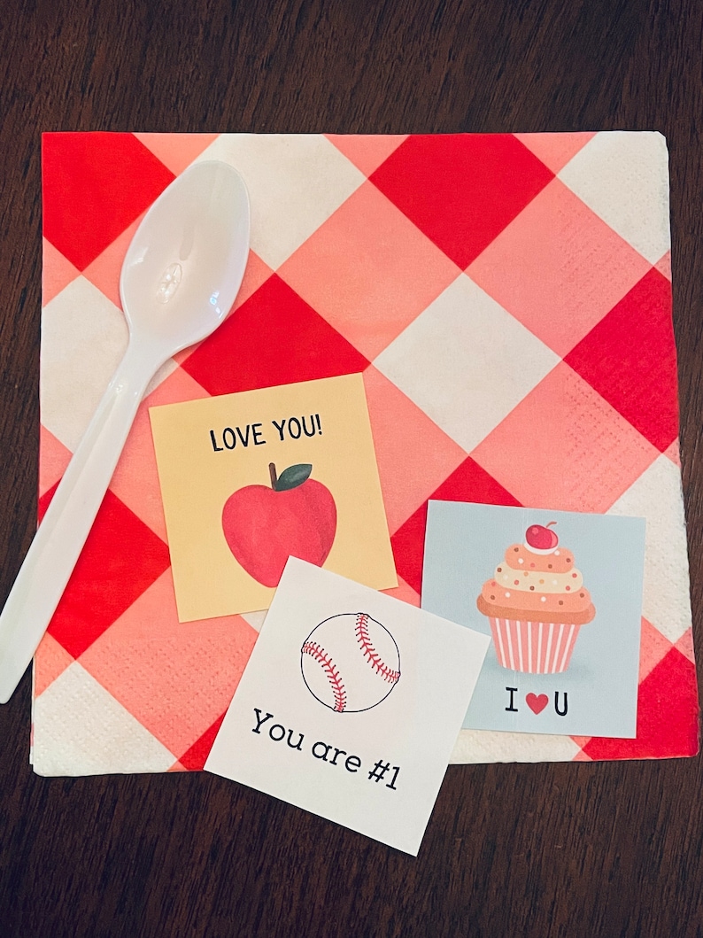 May include: Three small cards with different designs on a red and white checkered background. The first card has a red apple with a green stem and leaf and the text "LOVE YOU!" The second card has a baseball and the text "You are #1". The third card has a cupcake with a cherry on top and the text "I &hearts; U".