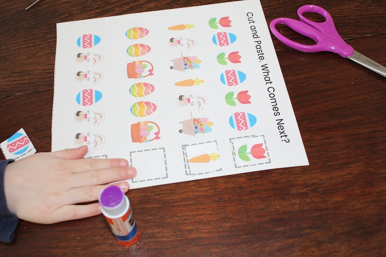 May include: A printable Easter activity sheet with a cut and paste game. The sheet has images of Easter eggs, bunnies, carrots, and tulips. The instructions read "Cut and Paste. What Comes Next?"