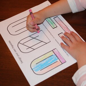 K&ouml;nnte beinhalten: Ein ausdruckbares Arbeitsblatt mit dem Text "Design your own Popsicles" und drei Eis am Stiel-Umrisse zum Ausmalen. Die Umrisse sind teilweise mit blauen, gr&uuml;nen, orangefarbenen und rosa Buntstiften ausgemalt.