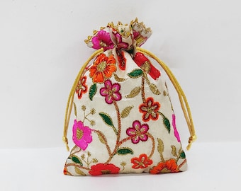 May include: Ivory drawstring bag with embroidered floral design in shades of pink, orange, and red. The flowers are accented with gold thread and green leaves. The bag has a gold drawstring closure.