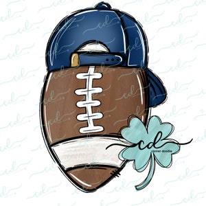 May include: A brown and white football with a blue baseball cap on top. A green four-leaf clover is on the side of the football.