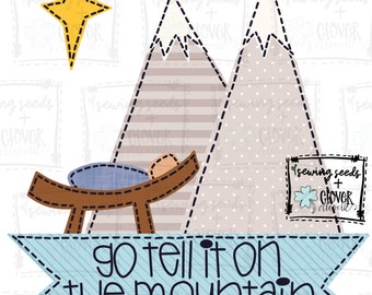Puede incluir: Una pancarta azul y blanca con el texto "go tell it on the mountain" sobre un fondo de dos montañas grises con cumbres blancas de nieve y un pesebre marrón con un bebé dentro. Una estrella amarilla está sobre las montañas.