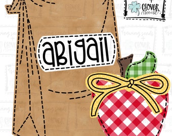 May include: A brown paper lunch bag with a label that says "abigail" and a red and white checkered apple with a yellow bow. The apple has a green leaf on top.