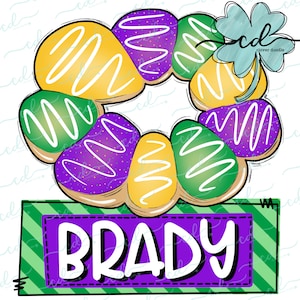 May include: A purple, green, and yellow donut wreath with white icing and sprinkles. The wreath is topped with a green shamrock and a sign that says "BRADY" in purple letters.