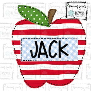 Pode incluir: Maçã vermelha e branca listrada com uma folha verde e bolinhas brancas. A maçã tem um rótulo xadrez azul e branco com o nome "JACK" em preto.