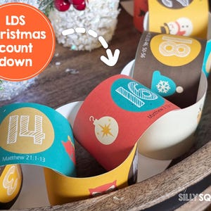 May include: A colorful Christmas countdown calendar with numbers 14, 16, and 18 visible. Each section is decorated with Christmas-themed illustrations and Bible verses. The text "LDS Christmas count down" is in an orange circle.