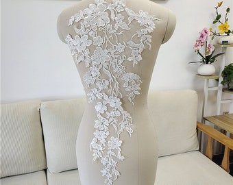 May include: White floral lace applique with delicate flowers and leaves. This lace trim is perfect for adding a touch of elegance to wedding dresses, bridal accessories, or other craft projects.