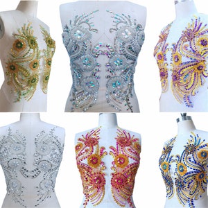 May include: Six different rhinestone applique designs for clothing. The designs feature a floral motif with a variety of colours, including gold, silver, purple, blue, pink and red.