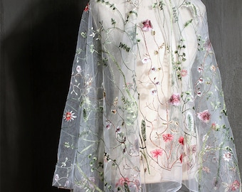 May include: White sheer fabric with embroidered floral designs in shades of green, pink, and red.