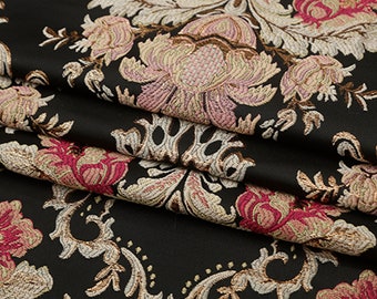 May include: Black fabric with a floral damask pattern in shades of pink, cream, and gold. The fabric has a raised texture and a luxurious feel.