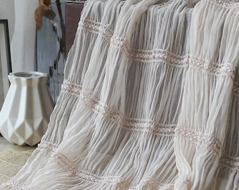May include: White sheer fabric with delicate ruched detailing and a subtle embroidered pattern. The fabric has a soft, flowing texture and is perfect for creating romantic and elegant garments.