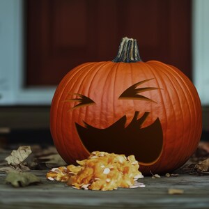 May include: A carved pumpkin with a wide, toothy grin and a mischievous expression. The pumpkin is sitting on a wooden surface with fallen leaves scattered around it.