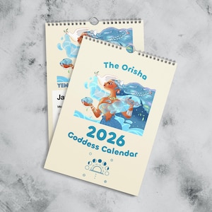 Puede incluir: Calendario de Diosa 2026 con espiral, con una ilustración vibrante de una diosa con cabello azul. El calendario tiene el texto "The Orisha" y "Goddess Calendar" sobre un fondo beige claro.