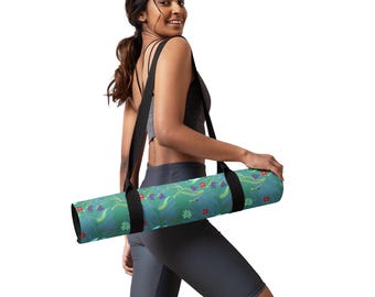 May include: A woman carrying a yoga mat with a floral pattern in shades of green, blue, red, and purple. The mat has a black strap with a shoulder strap.