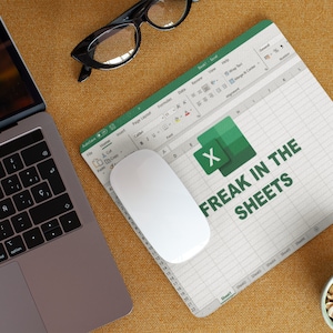 May include: A white mouse mat with a green Excel spreadsheet design. The text "FREAK IN THE SHEETS" is printed on the mouse mat.