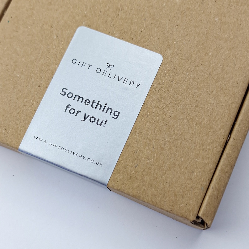 May include: A brown cardboard box with a silver label that reads "GIFT DELIVERY" and "Something for you!" The website address www.giftdelivery.co.uk is also visible. The box is partially open.