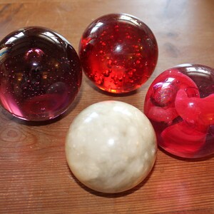 Four Large Spherical Paperweights; Glass and Alabaster, vintage controlled bubble red and purple paperweights, beautiful and collectible.