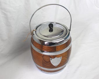 Wooden Biscuit Barrel; Vintage barrel with silver coloured bands, lid, handle and shield decoration and ceramic liner.