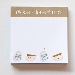 May include: A white notepad with a brown header that says "things i knead to do". The notepad has a design of flour sacks and rolling pins with cute faces.