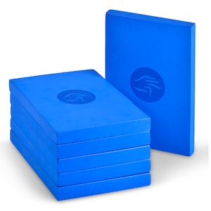 May include: A stack of six bright blue rectangular foam blocks, with a seventh block standing upright behind them. Each block has a circular emblem in the center. The blocks are a solid, vibrant blue color.