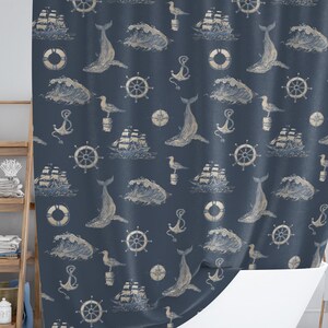 May include: Navy blue shower curtain with a nautical pattern. The design features whales, ships, waves, anchors, seagulls, and life preservers in a cream color. The curtain is hanging in front of a white bathtub.