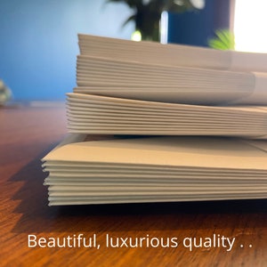 An image of a pile of moving house cards and envelopes with the text overlayed saying 'beautiful, luxurious quality.'