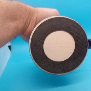 Pu&ograve; includere: Il fondo di una tazza in ceramica blu con un anello di gomma nero attorno alla base. La tazza ha un cerchio bianco al centro dell'anello di gomma.
