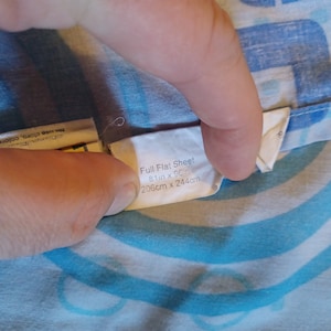 May include: White tag with black text that reads "Full Flat Sheet 81in x 96in 206cm x 244cm".