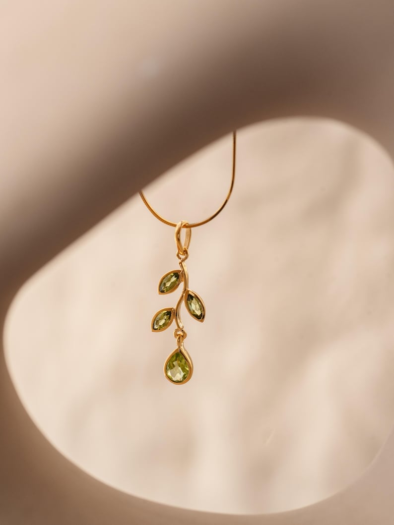 Gold leaf necklace featuring marquise leaves and a pear-cut peridot drop. Crafted from 24k gold vermeil over 925 sterling silver, these earrings are inspired by nature, highlighting the vibrant green. Also available with a matching earrings and ring.