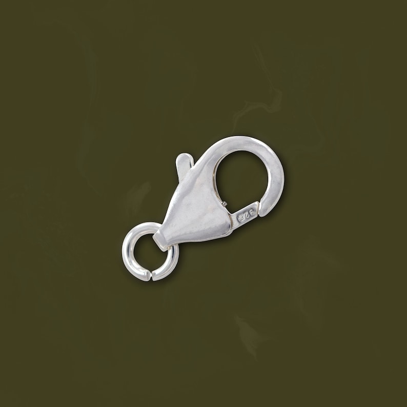 May include: Silver lobster clasp with a spring ring closure. The clasp is marked with "925" indicating sterling silver.