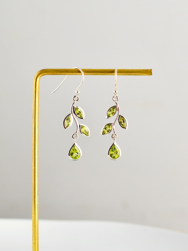 Gold leaf earrings featuring marquise leaves and a pear-cut peridot drop. Crafted from 24k gold vermeil over 925 sterling silver, these earrings are inspired by nature, highlighting the vibrant green. Also available with a matching necklace and ring.