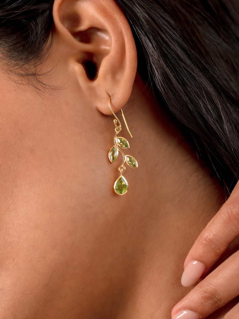 Gold leaf earrings featuring marquise leaves and a pear-cut peridot drop. Crafted from 24k gold vermeil over 925 sterling silver, these earrings are inspired by nature, highlighting the vibrant green. Also available with a matching necklace and ring.