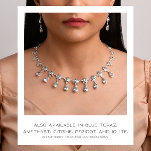 Puede incluir: Un collar de plata con una cadena delicada y piedras de topacio azul en forma de l&aacute;grima. El collar tambi&eacute;n est&aacute; disponible en amatista, citrino, peridoto e iolite.