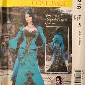 May include: McCall's Costumes pattern M7218 featuring Yaya Han's Original Peacock Costume. The teal dress has peacock feather detailing on the bodice and skirt. The pattern includes sizes A5 (6-8-10-12-14).