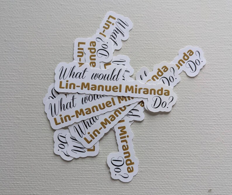 Puede incluir: Una colecci&oacute;n de pegatinas blancas con texto negro y detalles dorados. Las pegatinas muestran la frase "What would Lin-Manuel Miranda Do?" en varios tama&ntilde;os y orientaciones.